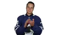 a man wearing a toronto maple leafs jersey is clapping his hands