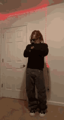 a person with dreadlocks standing in front of a door