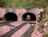 a train is coming out of a tunnel with a face on the front