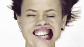 a close up of a woman making a funny face with her mouth open and her eyes closed .