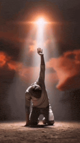 a person kneeling down with their hand up in the air