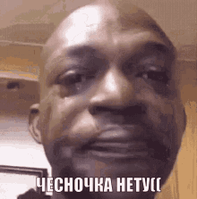 a close up of a man 's face with a tear coming out of his eye and a caption in russian .