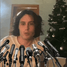 a man is surrounded by a bunch of microphones including one that says ' a ' on it