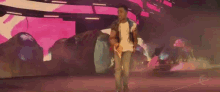 a man is walking on a stage in front of a purple and pink background