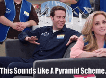 a man in a blue shirt with the word clouds on it sits next to a woman