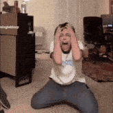 a man is kneeling down with his hands on his head in front of a box that says ningleblorp on it