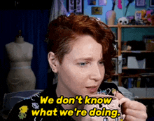a woman with red hair is holding a mug and saying we don t know what we 're doing