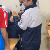 a man in a blue and white jacket has a patch on his sleeve that says ' saigon '