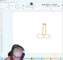 a bald man wearing headphones looks at a drawing of a penis on a computer screen