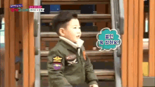 a little boy in a military uniform is standing on a set of stairs