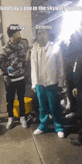 a group of men are standing in a queue and one of them is wearing a white jacket and blue pants