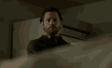 a man with a beard stands in front of a white door