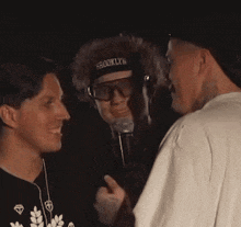 two men are hugging each other and smiling in the dark