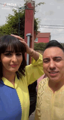 a man and a woman are posing for a picture with tiktok written on the bottom right