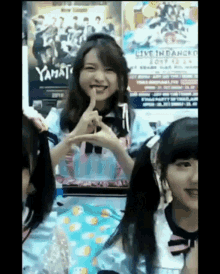 a group of young girls are sitting in front of a yamato poster