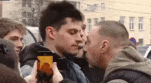 a man taking a picture of another man with a cell phone