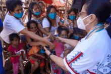 a woman wearing a mask shakes hands with a group of people wearing masks