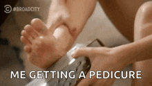 a person is getting a pedicure on their foot with a nail file .