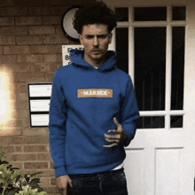 a man wearing a blue hoodie that says marrek