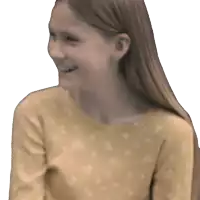 a girl in a yellow shirt with white polka dots smiles