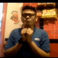 a man wearing glasses and a blue shirt that says mbc