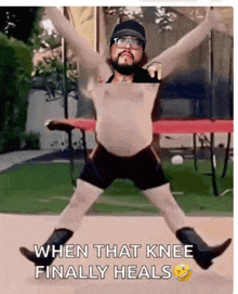 a shirtless man is jumping on a trampoline with the words when that knee finally heals