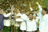 a group of men in white coats are holding a trophy and celebrating