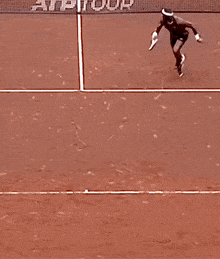a person laying on a tennis court with the word atp on it