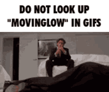 a man in a suit and tie is sitting on a couch looking at a person laying on the floor .