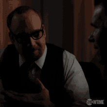 a man in glasses talks to another man with showtime written on the bottom
