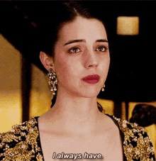 a woman says i always have while wearing a black and gold dress