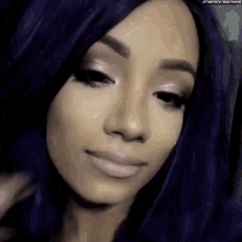 a close up of a woman 's face with purple hair and pink eyeshadow .