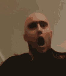 a bald man is making a surprised face with his mouth wide open