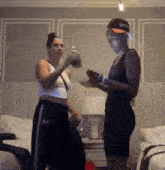 two women standing next to each other one wearing a hat that says jesus on it