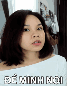 a woman 's face is behind a sign that says " de minh noi " on it