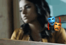 a woman is sitting in front of a laptop with two masks on her shoulder