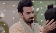 a man with a beard is touching a woman 's head