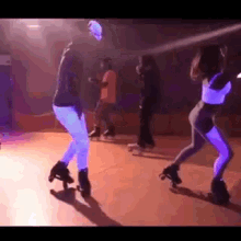 a group of people are rollerblading in a dark room with purple lights .