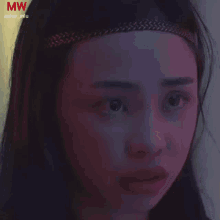 a close up of a woman 's face with the letters mw on the bottom right