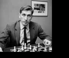 a man in a suit and tie is playing chess on a table .