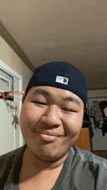 a man wearing a hat with the letter f on it is smiling