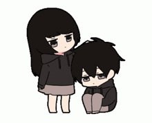 a girl is standing next to a boy who is sitting on the floor