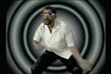 a man with glasses and a beard is dancing in a circle