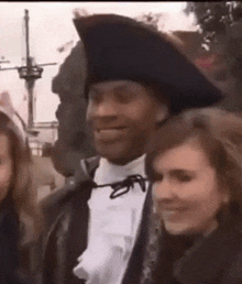 a man wearing a pirate hat is smiling while standing next to a woman .