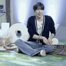 a man is sitting on the floor with his legs crossed and his tongue hanging out .