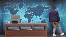 a man is standing in front of a map of the world