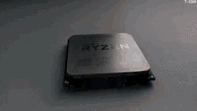 a close up of a ryzen processor on a gray surface .