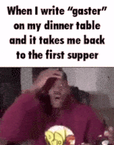 a man is sitting at a table with his hand on his head .