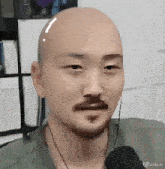 a man with a bald head and a mustache is shown in a video created by vidu al