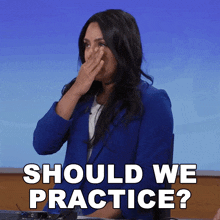 a woman in a blue jacket covering her nose with her hand and the words should we practice
